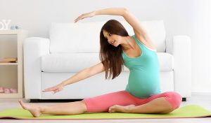 A pregnant woman doing exercise on mat
