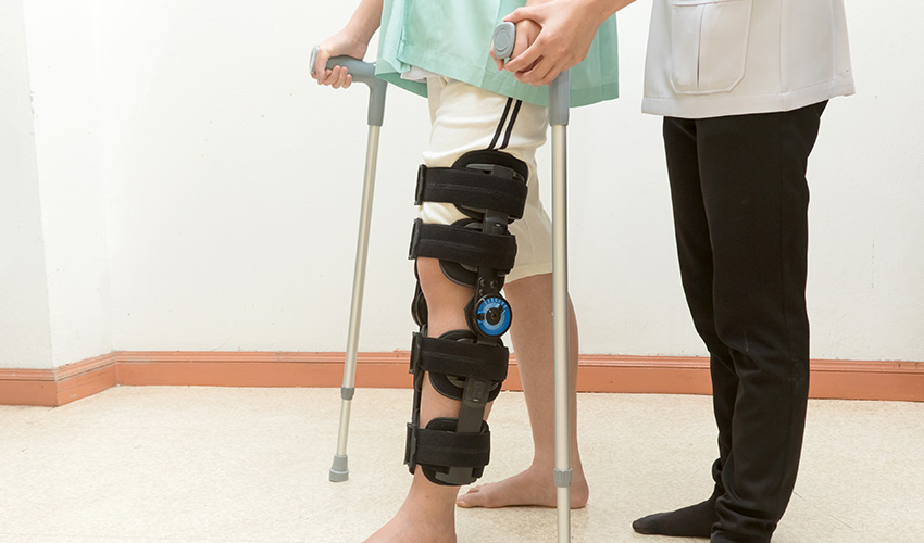 A doctor helping a patient in walking exercise after surgery