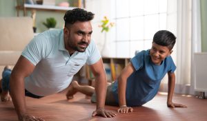 A young Indian father doing work out with his kid